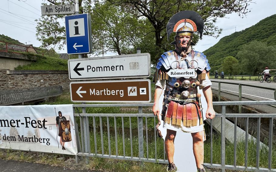 Cardboard cutout of a Roman soldier with an arrow that reads “Römerfest” and pointing left.